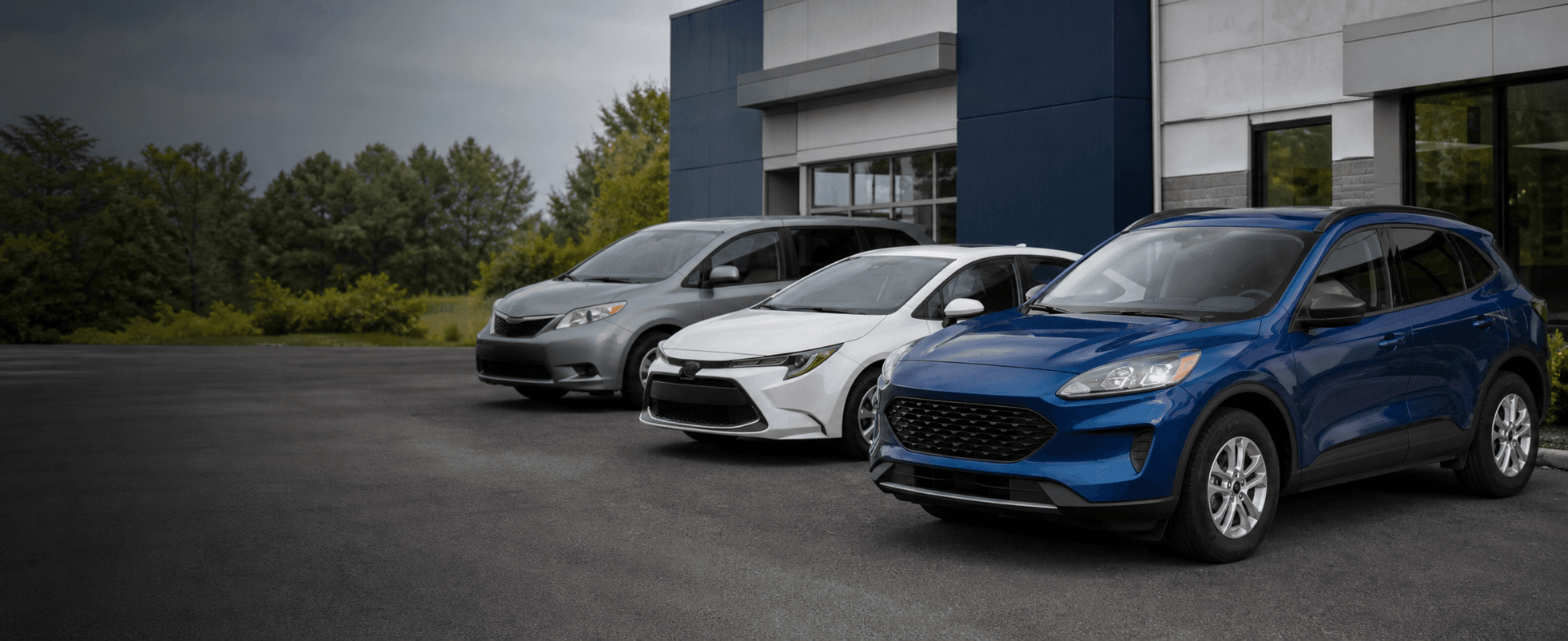 A representative lineup of practical vehicles outside a modern dealership